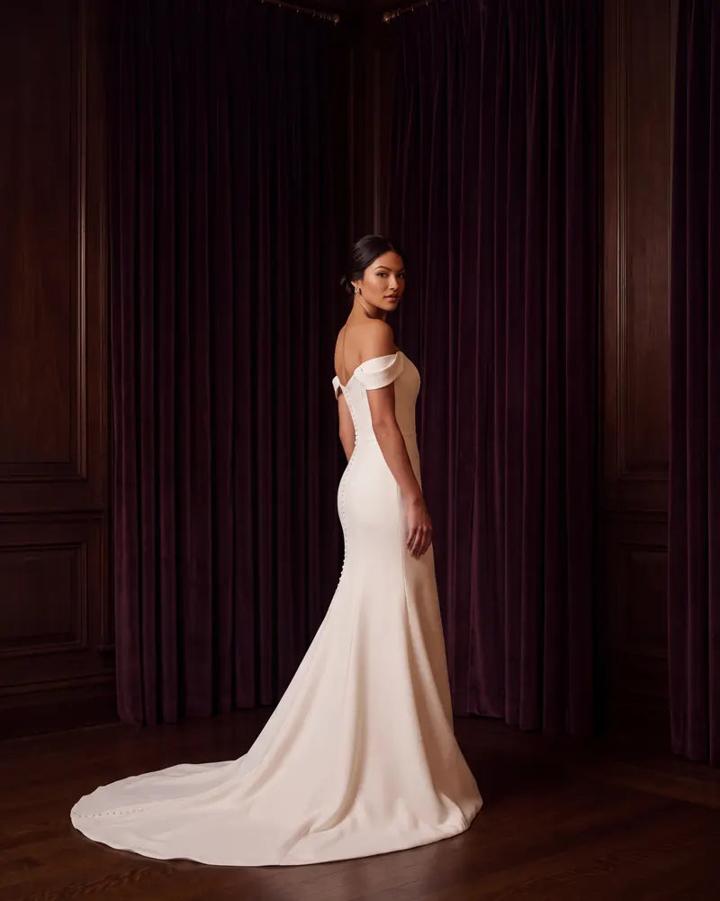 Vestido de novia de P&S Designs junto a una ventana